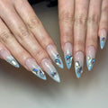 Handmade press-on nails with icy light blue shimmer, ombre design and gemstone accents