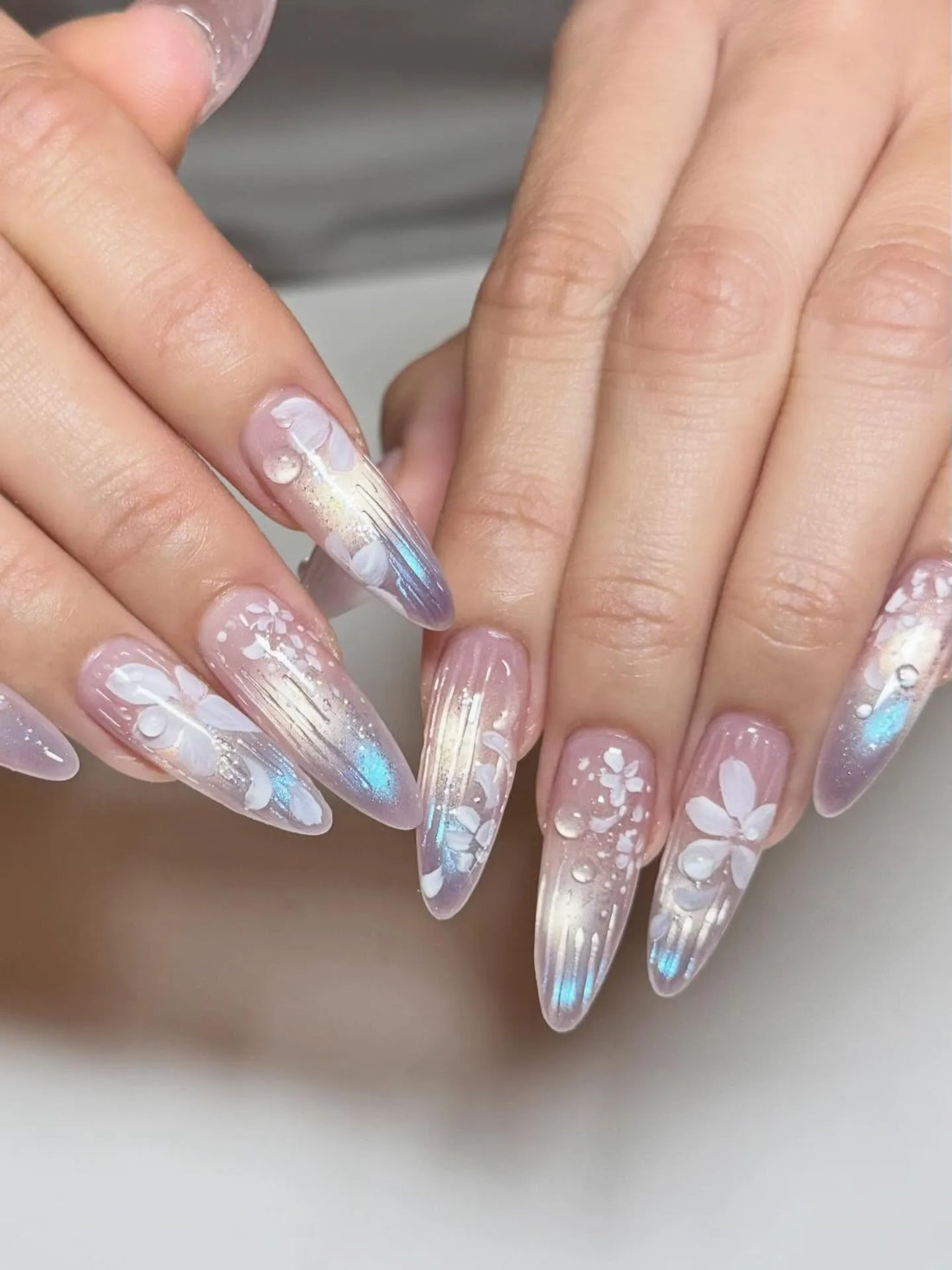 Handmade iridescent stiletto press-on nails with white floral and dewdrop design
