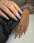 Hand with long iridescent pastel press-on nails, gold accents and pearl 3D details