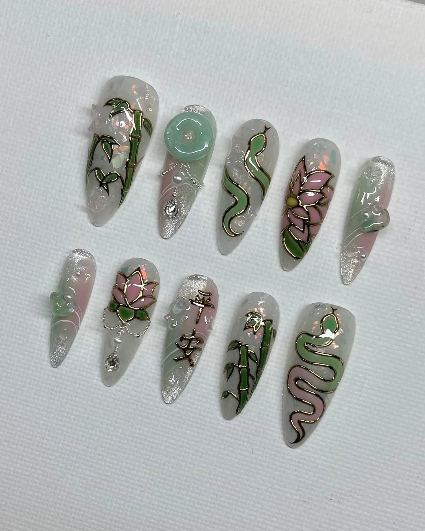 Handmade iridescent press-on nails with jade green bamboo, lotus, and snake Asian designs.