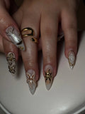 Hand with coastal press-on nails featuring 3D starfish, seashell, pearl and gold accents.
