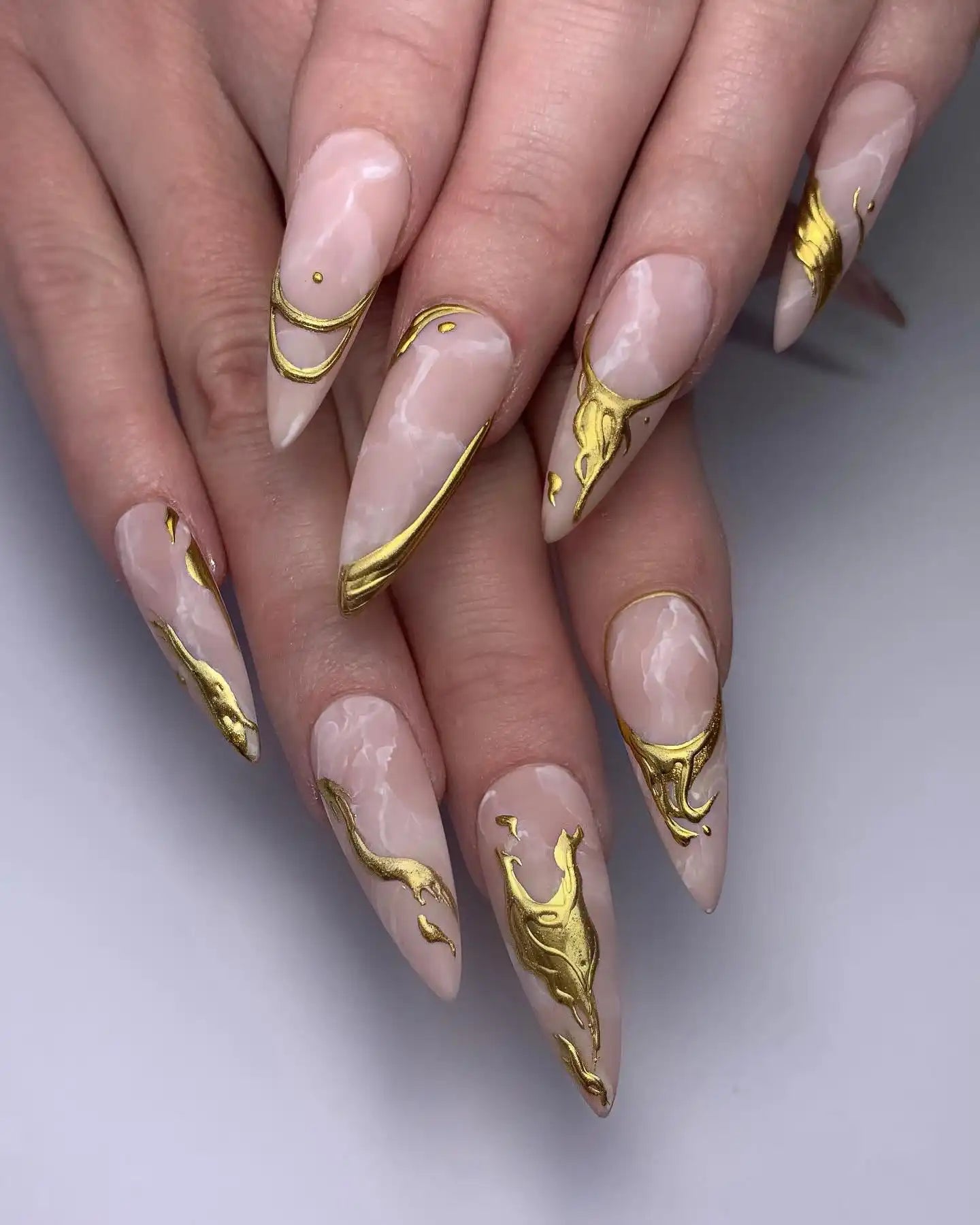 Handmade marble stiletto press-on nails with gold metallic molten fluid art design