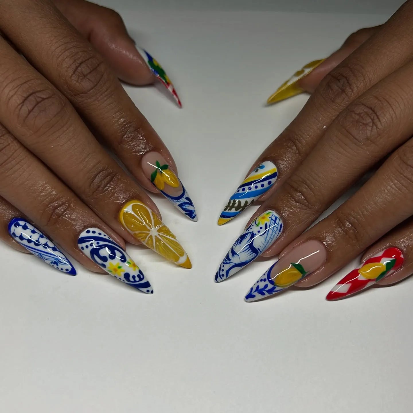 Handmade stiletto press-on nails with lemon, blue, white, and Mediterranean-inspired designs