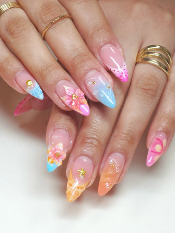 Hand with handmade mermaid shell and floral tropical 3D press-on nails, pastel colors