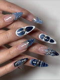Hand with midnight blue and white 3D floral celestial chrome stiletto press-on nails.