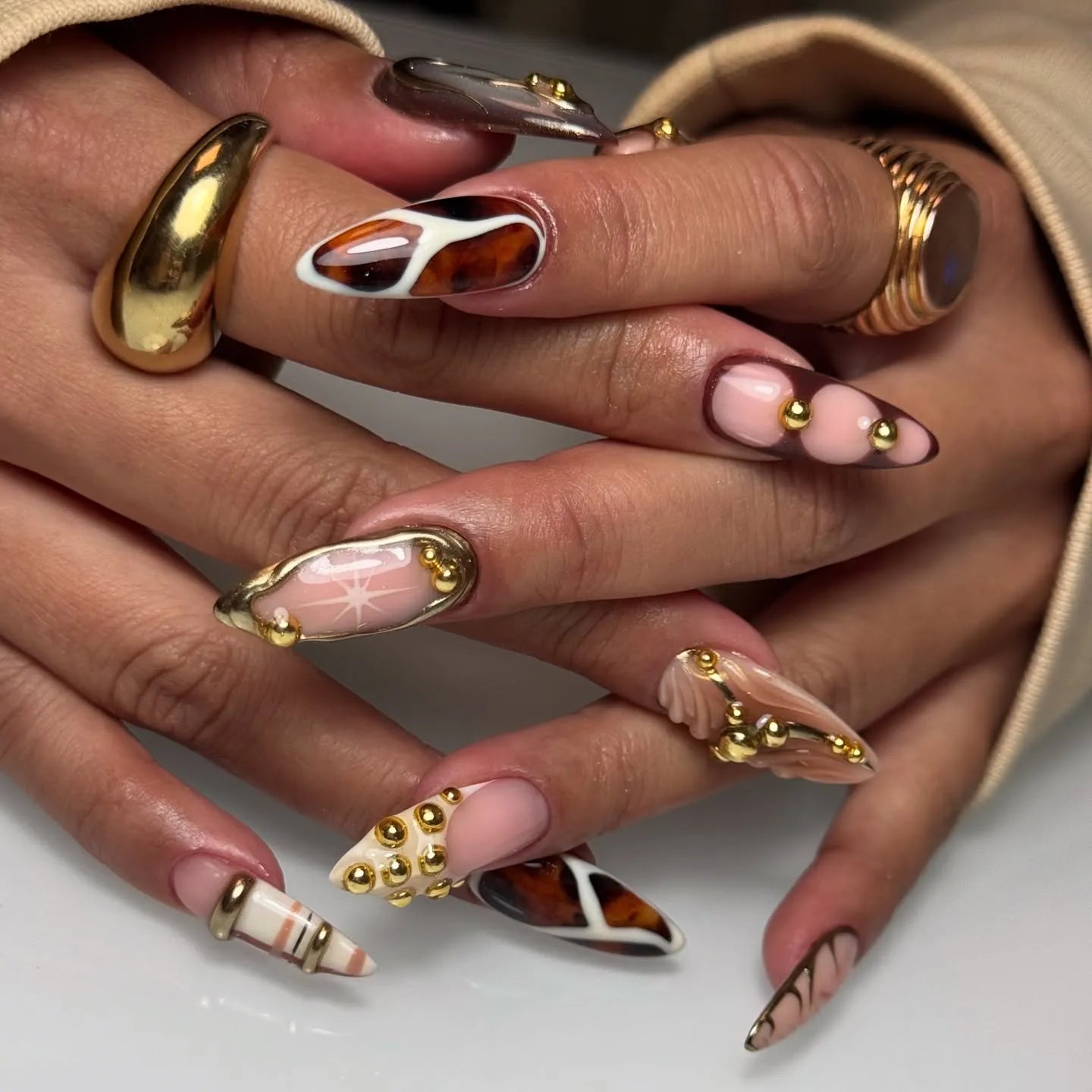 Handmade press-on nails with mixed tortoise shell, plaid, and gold studded designs.