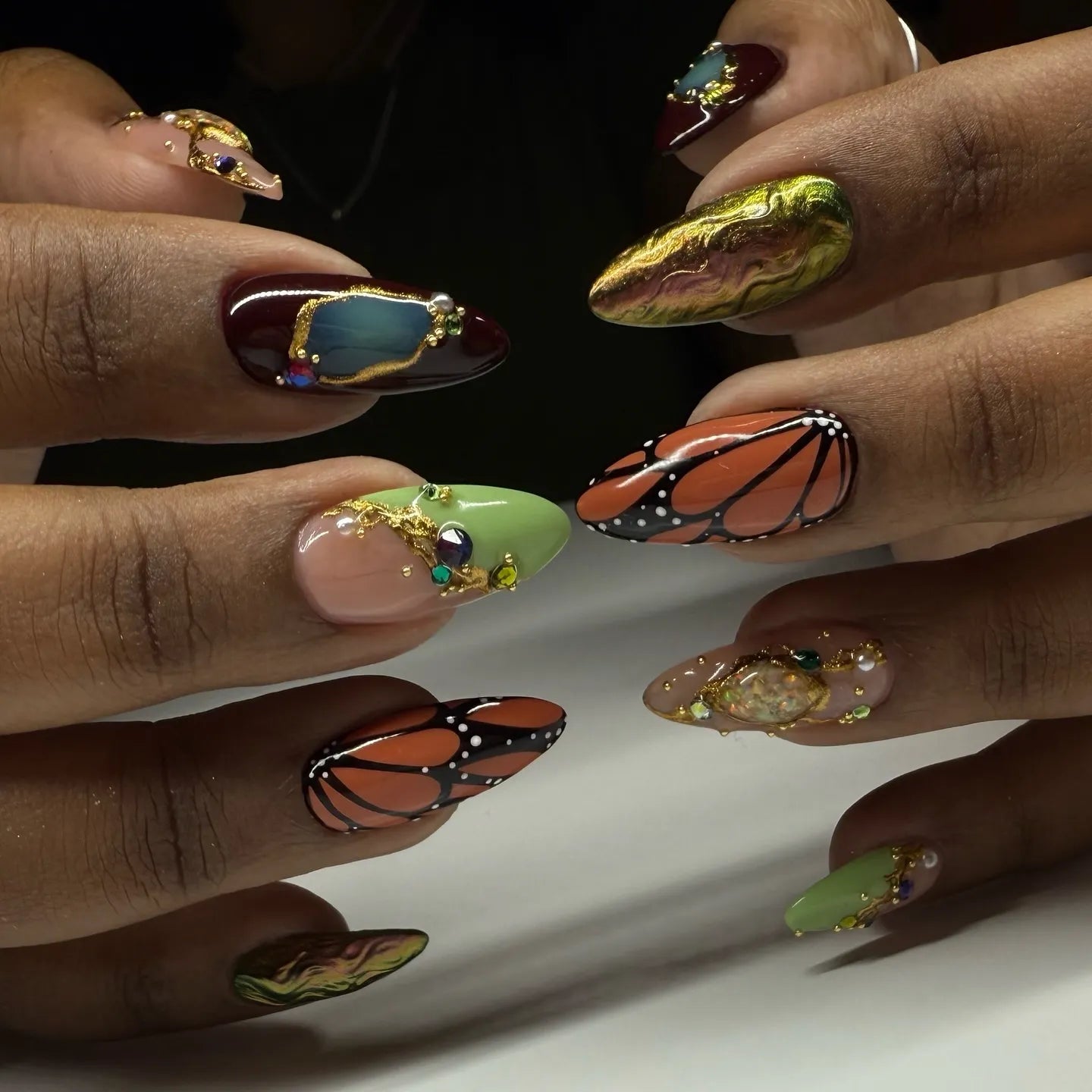 Handmade press-on nails with monarch butterfly wings, crystals, gold accents, and jewel art.