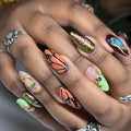 Hand with handmade monarch butterfly press-on nails and crystal jewel accents
