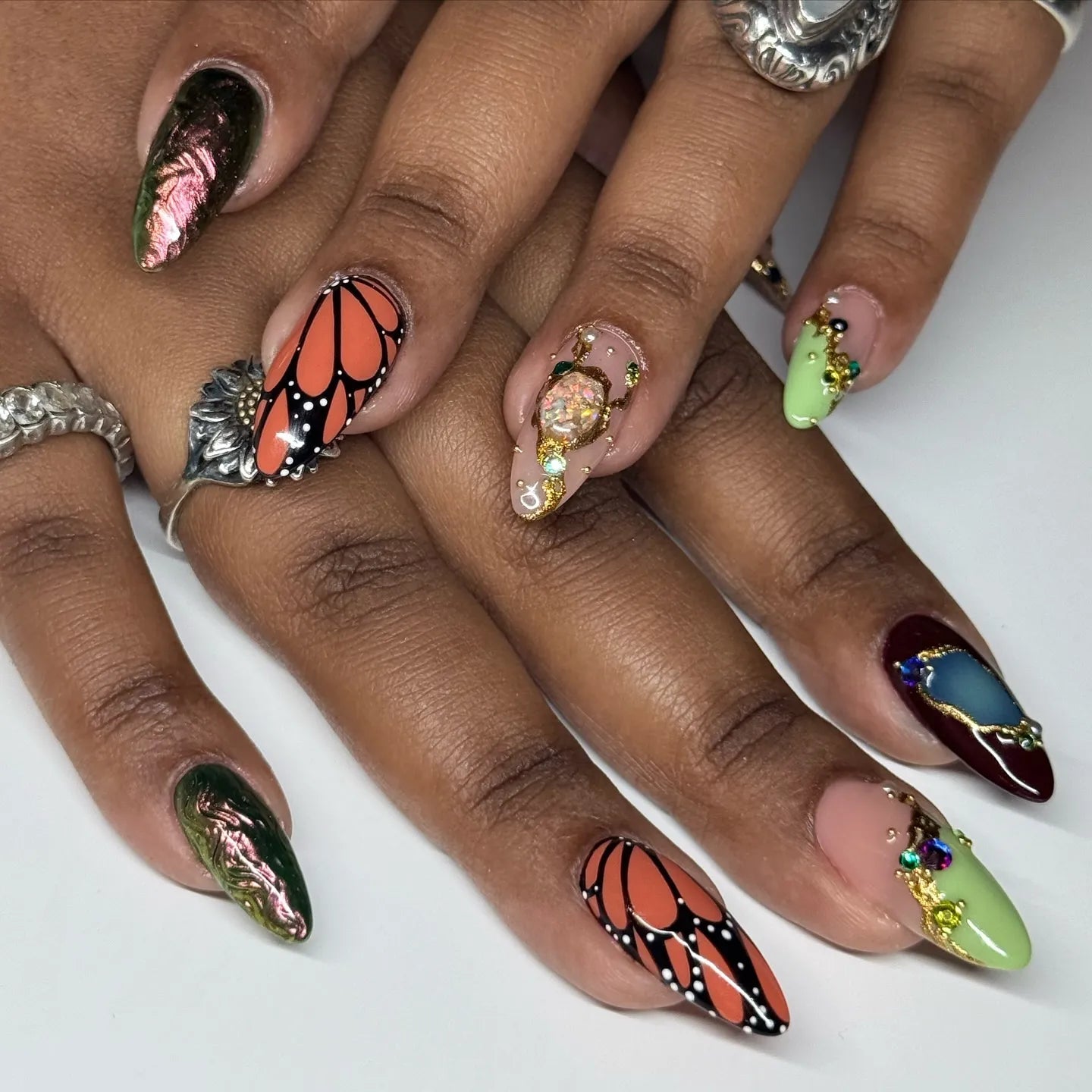 Handmade press-on nails with monarch butterfly art, crystals, jewel accents, and colorful designs.
