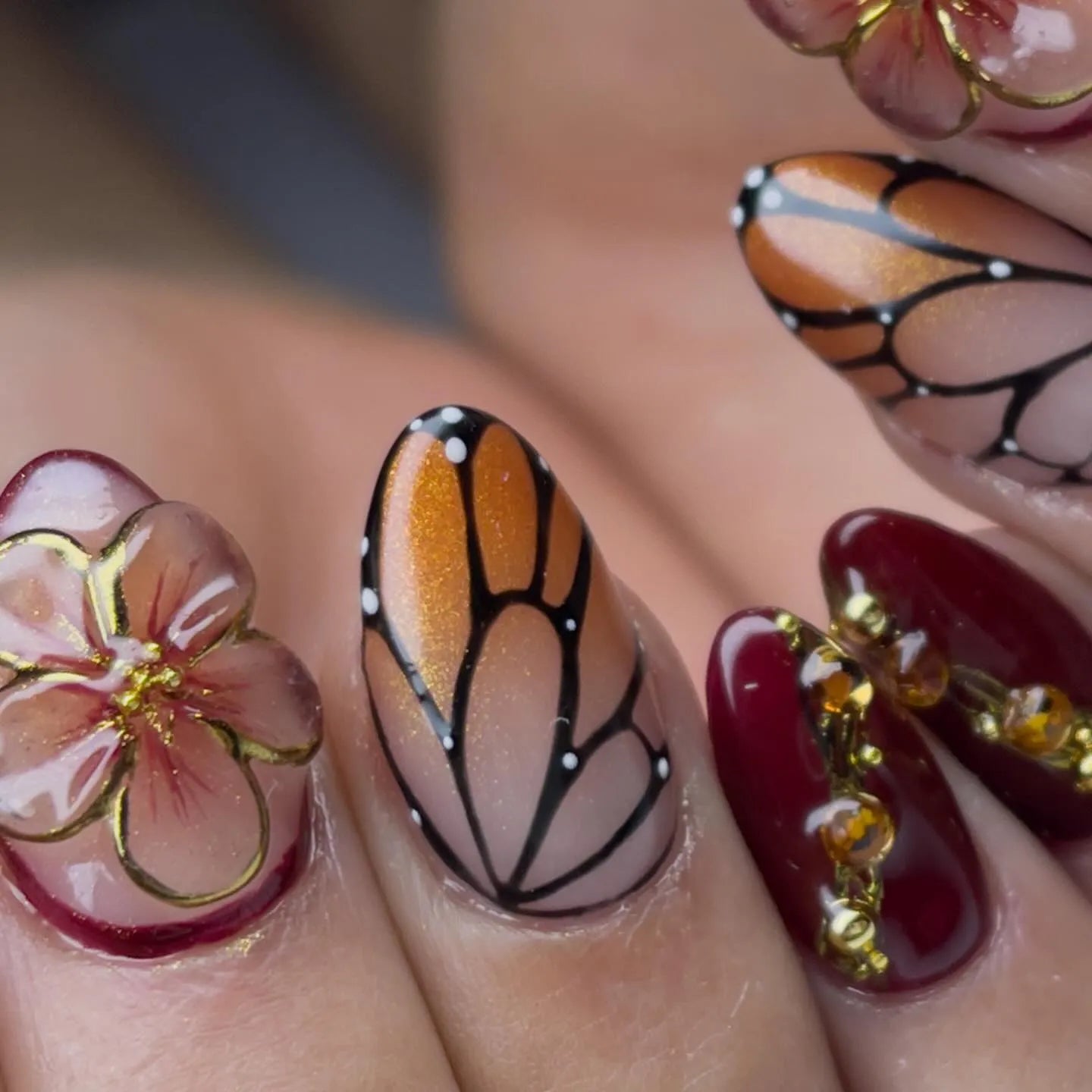 Handmade press-on nails with 3D amber floral designs, monarch butterfly wing art, and gold accents.