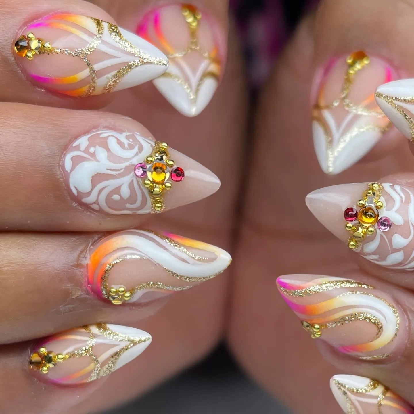 Handmade press-on nails with gold swirl, sunset gradient, white accents, and crystal gems