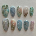 Handmade pale blue ocean-themed press-on nails with jellyfish, water lily, and silver accents.