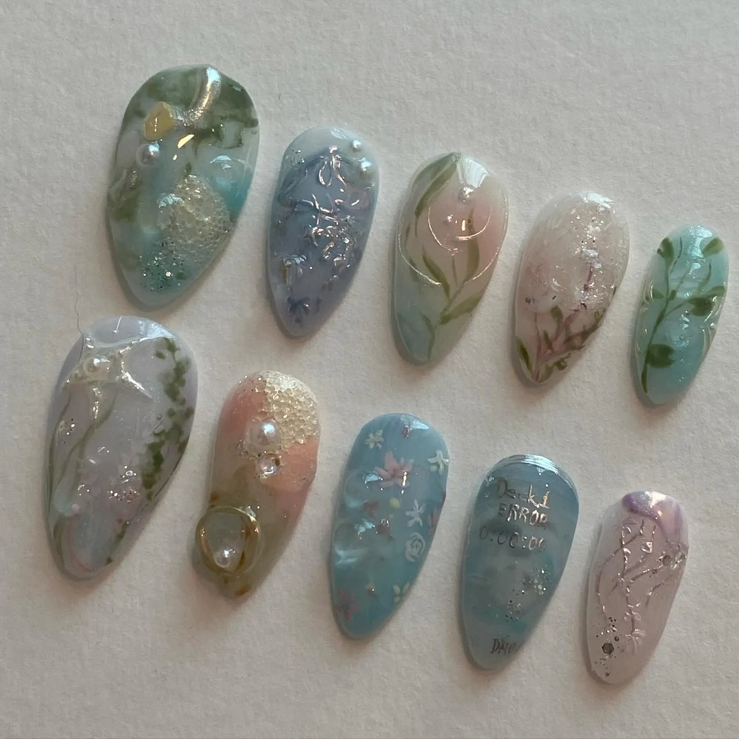 Handmade pale blue press-on nails with ocean, jellyfish, water lily designs and silver accents