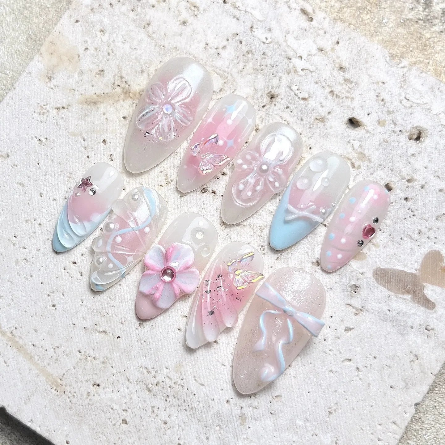 Handmade pastel press-on nails with butterfly, bow, flower, and pearl shimmer details