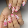 Hand with handmade pink 3D citrus blossom and pearl press-on nails, floral and textured design