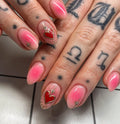 Handmade pink ombre press-on nails with gold starbursts and red heart accents