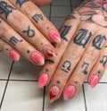 Handmade pink aura press-on nails with red sacred heart and gold starburst accents