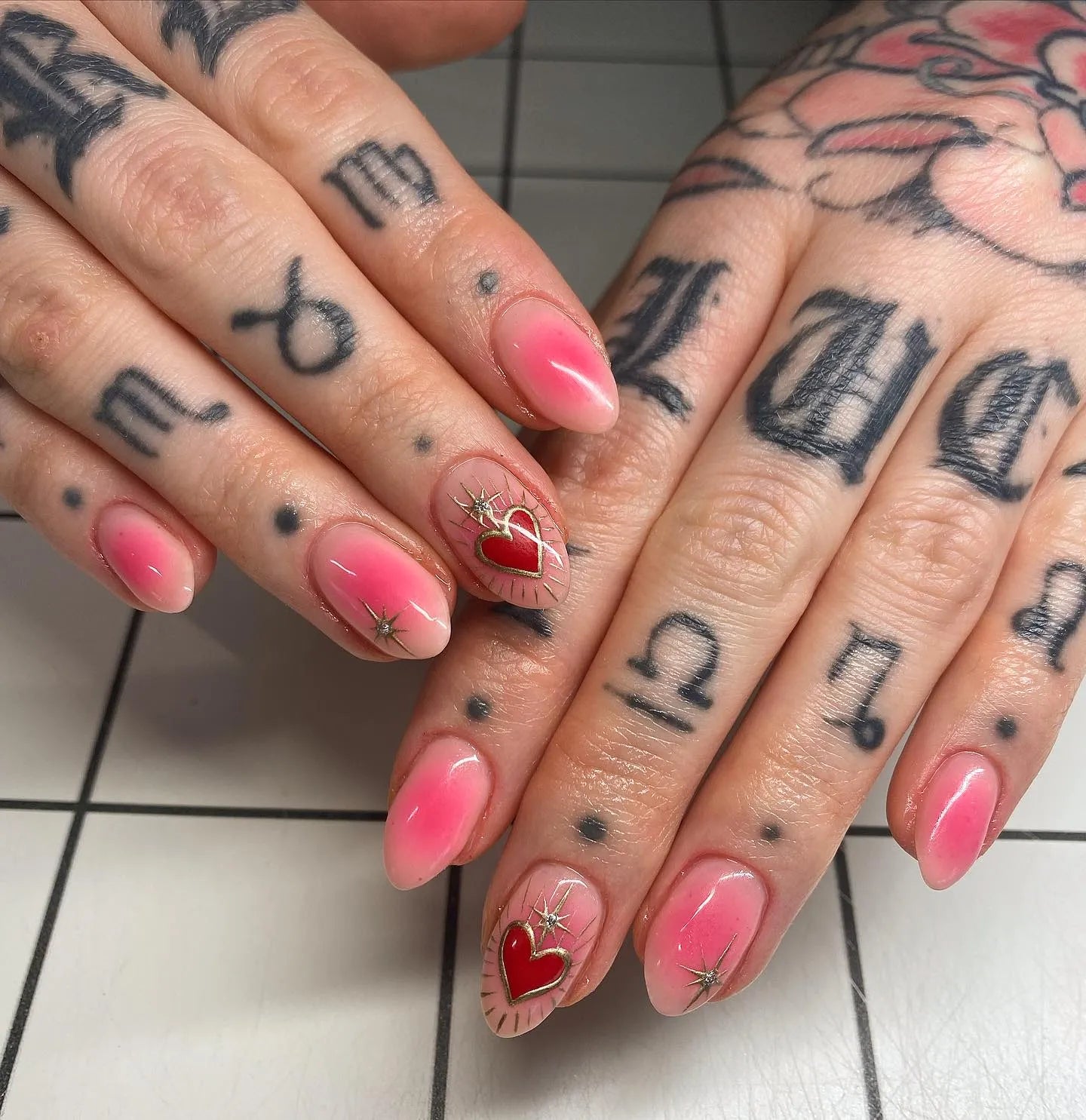 Handmade pink aura press-on nails with red sacred heart and gold starburst accents