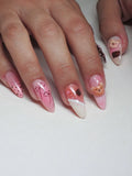 Hand with pink and brown 3D teddy bear, bow, lace, and polka dot press-on nails.