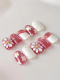 Handmade pink and white 3D daisy floral press-on nails with pearl accents.