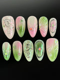 Handmade pink and green fairycore press-on nails with chrome butterfly wing designs and gems