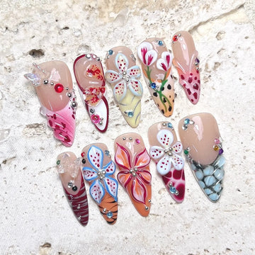 Handmade press-on nails with 3D floral, butterfly, seashell, and rhinestone designs on stone