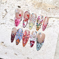 Handmade press-on nails with 3D butterfly, jellyfish, seashell and floral designs, embellished with rhinestones.