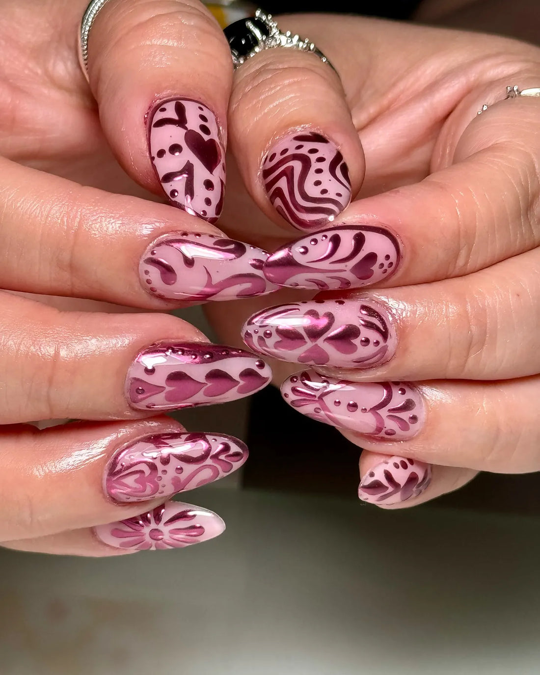 Handmade pink metallic chrome folk art heart press-on nails with intricate designs
