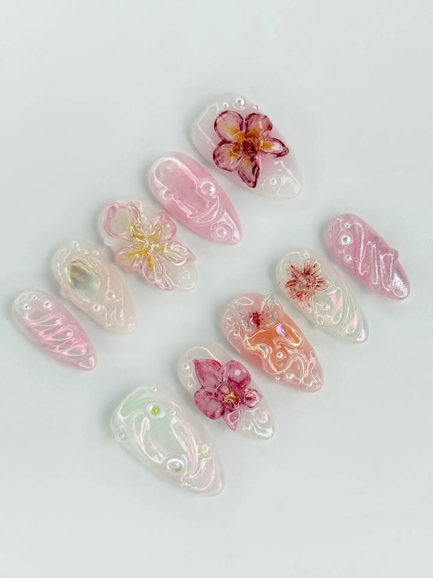 Handmade press-on nails with 3D pink orchid flowers and iridescent pearl accents.