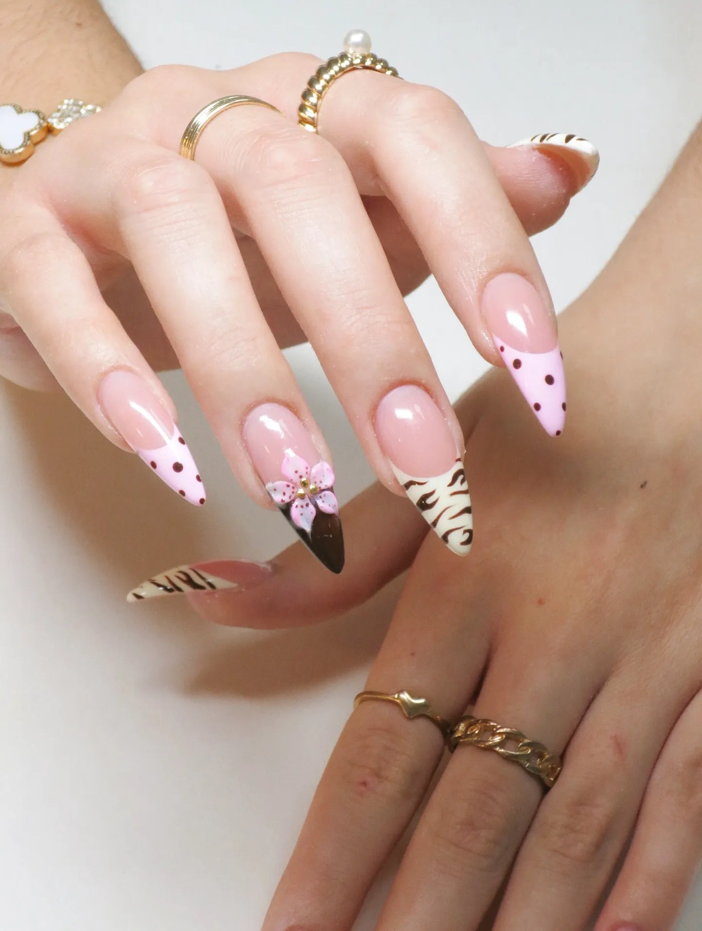 Hand with handmade pink polka dot, animal print, 3D flower French stiletto press-on nails