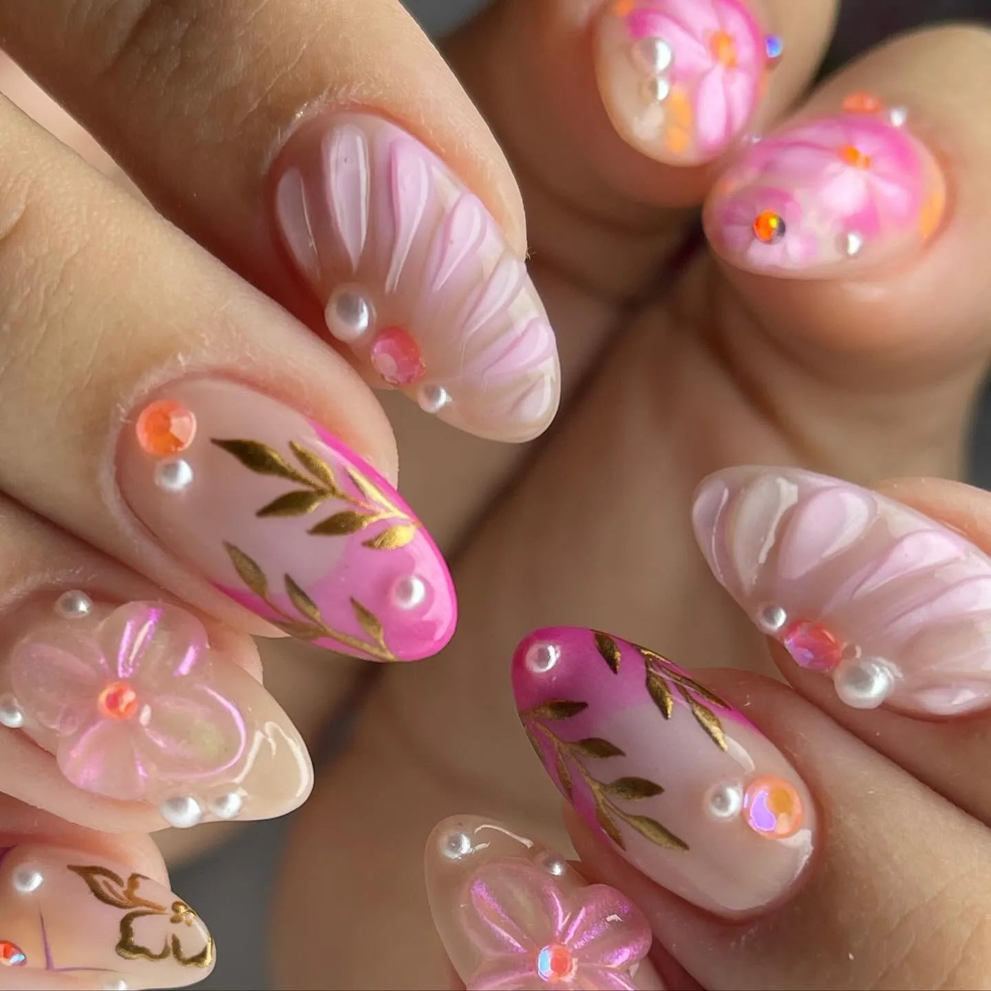 Handmade pink floral press-on nails with gold leaf, pearls, and gem accents