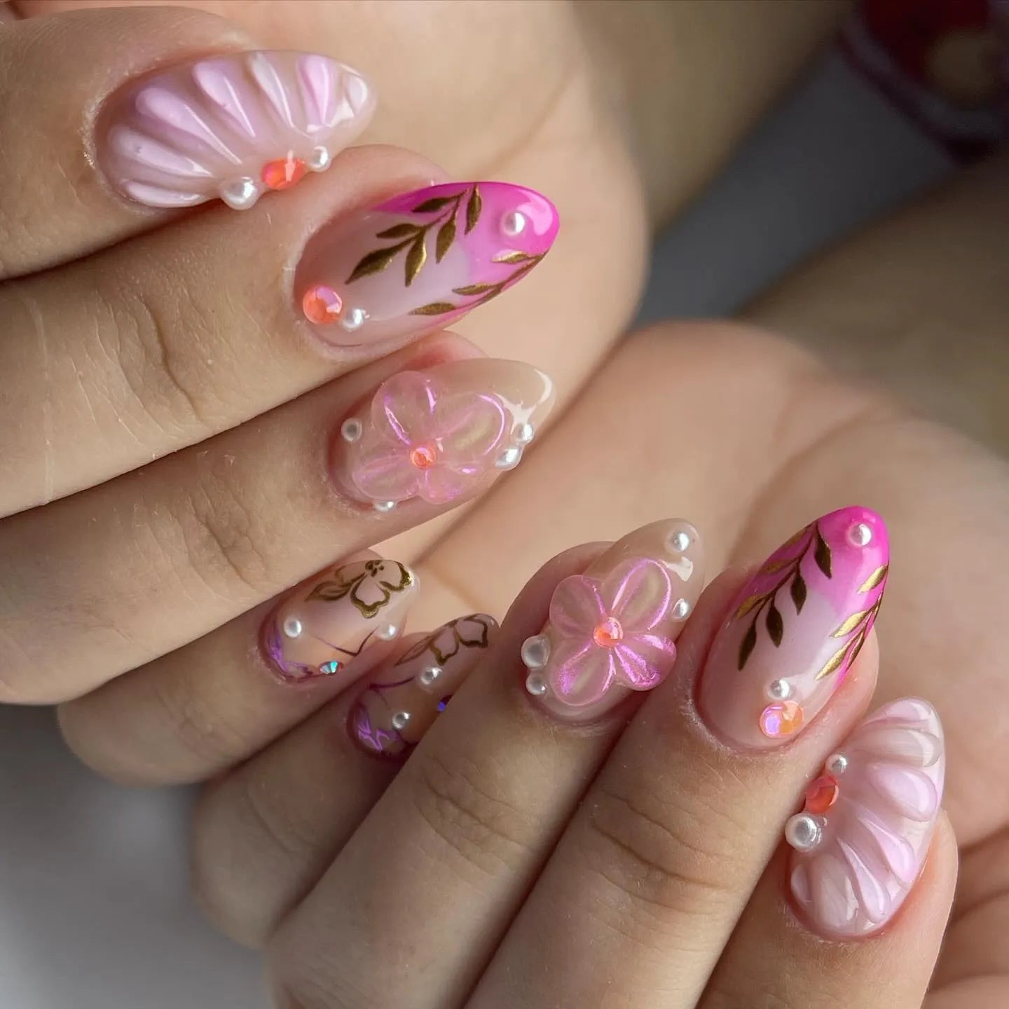Handmade pink shell and floral press-on nails with gold leaf, pearls, and 3D accents