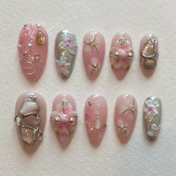 Handmade pink and silver chrome press-on nails with 3D flower, jewel, and pearl accents.