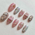 Handmade pink and silver press-on nails with 3D flower and jewel accents.