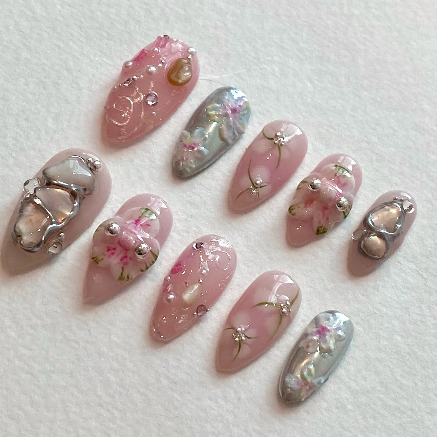 Handmade pink and silver press-on nails with 3D flower and jewel accents.