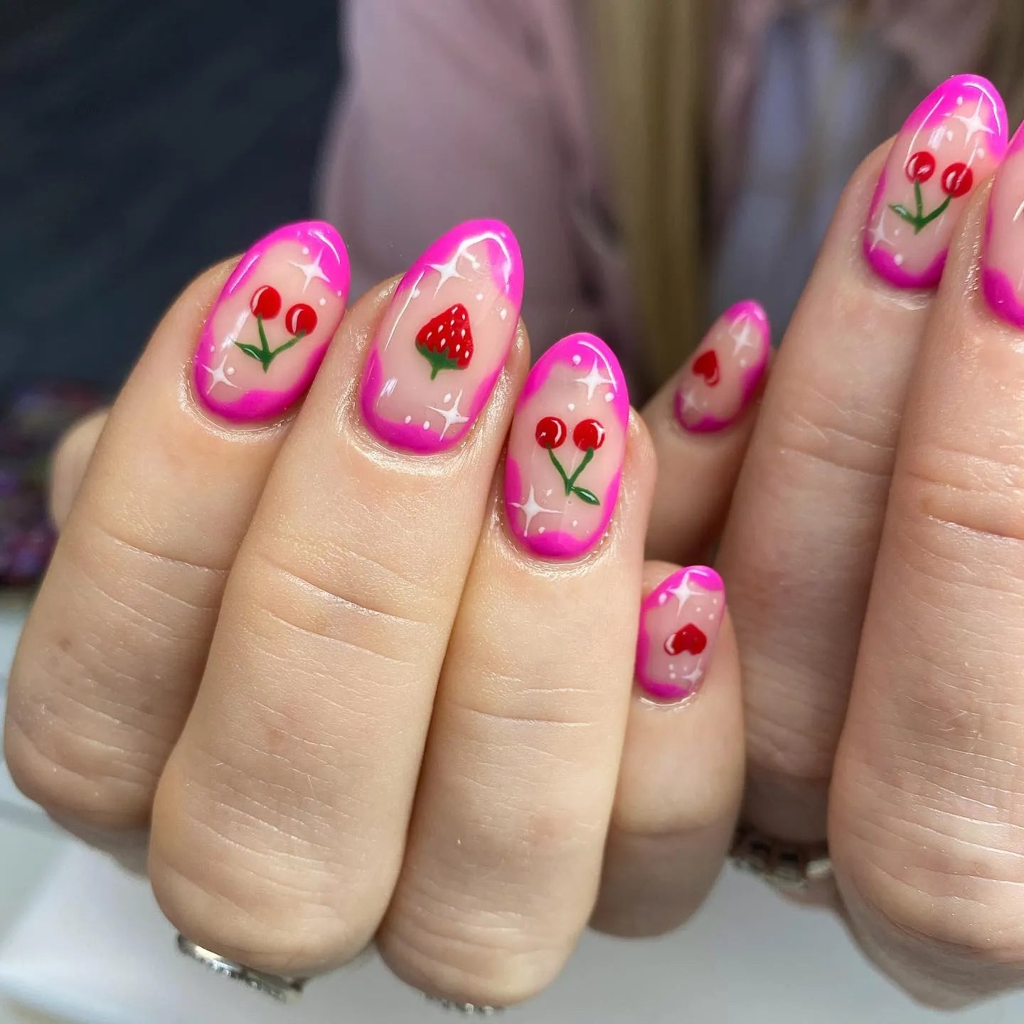 Handmade pink press-on nails with cherry and strawberry fruit art accents