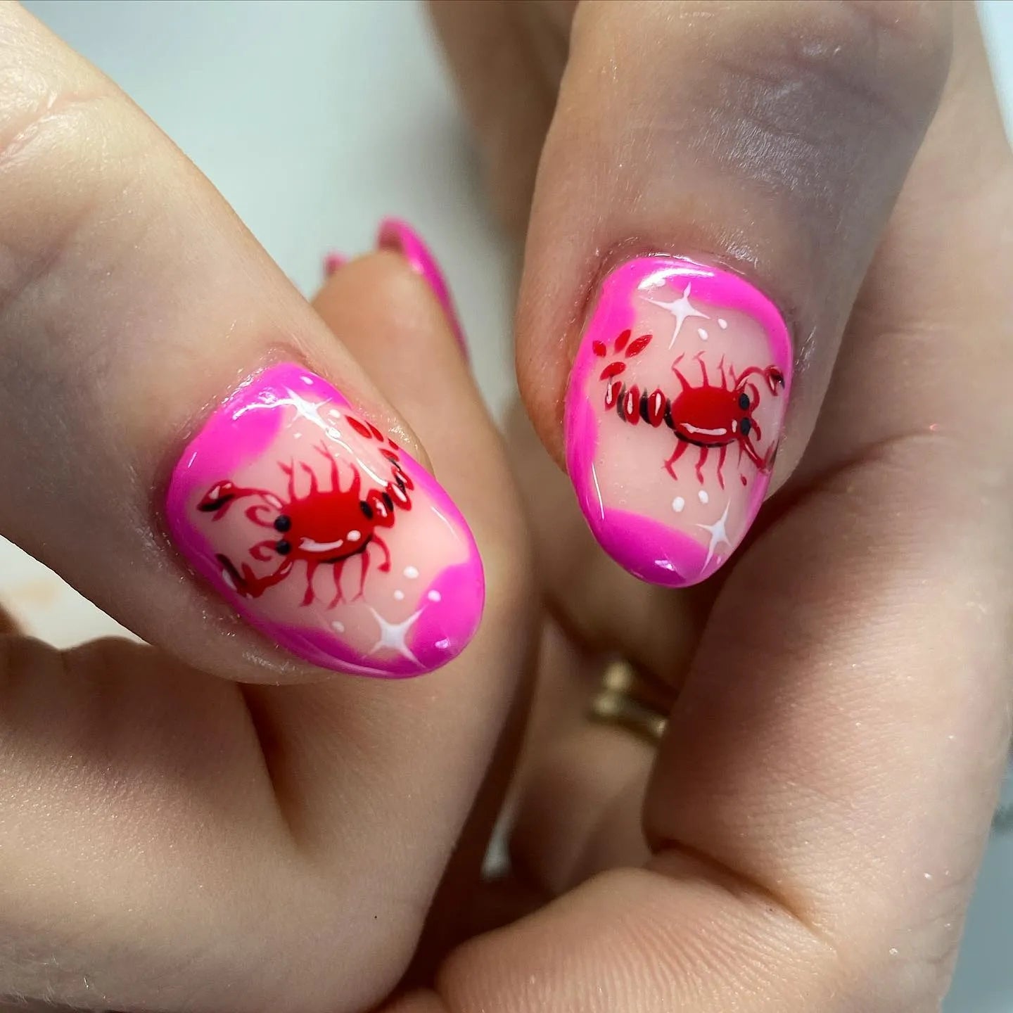 Handmade press-on nails with pink French tips and red crab nail art design