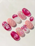 Handmade pink press-on nails with shimmer, bow designs, and knit texture accents.