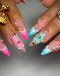 Handmade press-on nails with pink and teal ombre, 3D floral, seashell, and pearl accents.