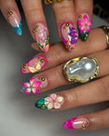 Handmade press-on nails with 3D floral designs in pink, teal, gold accents, and rhinestones.