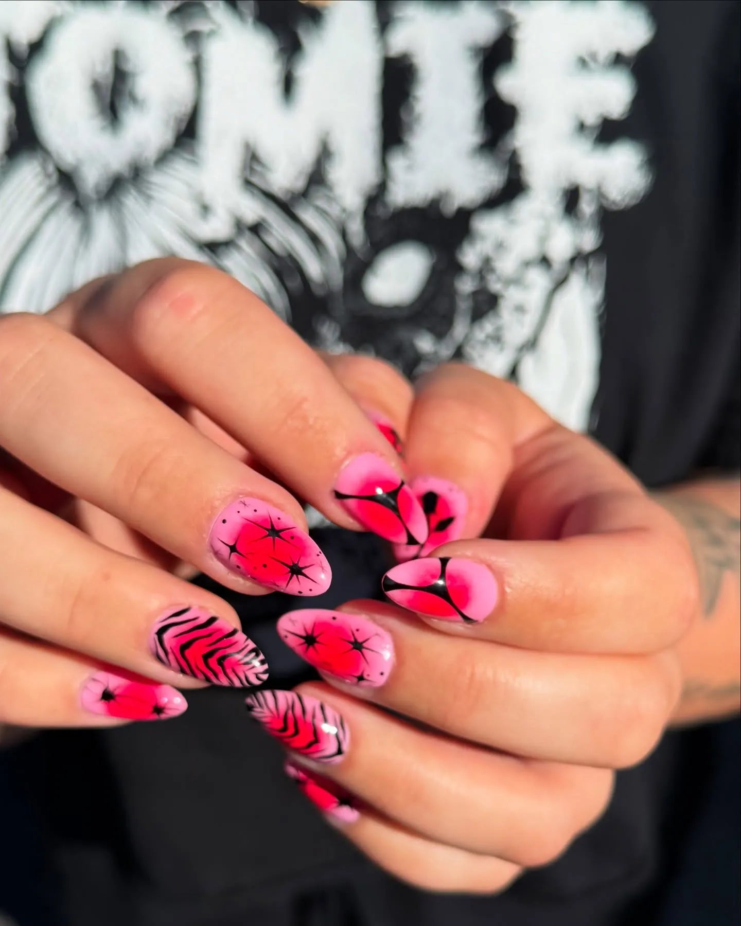 Handmade almond press-on nails with pink zebra and neon red starburst designs