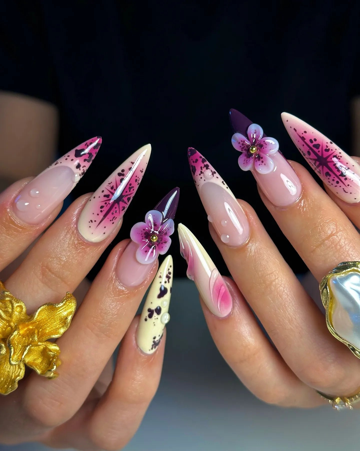 Handmade press-on nails with purple floral 3D art, star and galaxy designs, long almond shape.