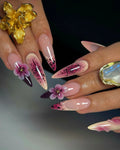Handmade stiletto press-on nails with purple floral 3D art and celestial galaxy accents.