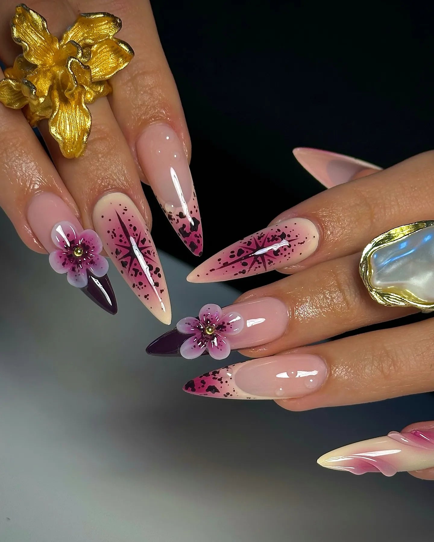 Handmade stiletto press-on nails with purple floral 3D art and celestial galaxy accents.