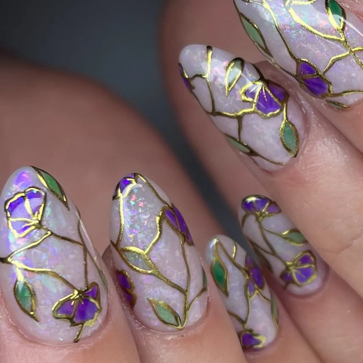 Handmade press-on nails with purple floral stained glass design and gold foil accents