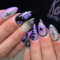 Handmade purple ombre floral and chrome star press-on nails with jeweled accents.