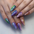 Hand with long, almond-shaped, rainbow velvet shimmer press-on nails, showing cat eye effect.