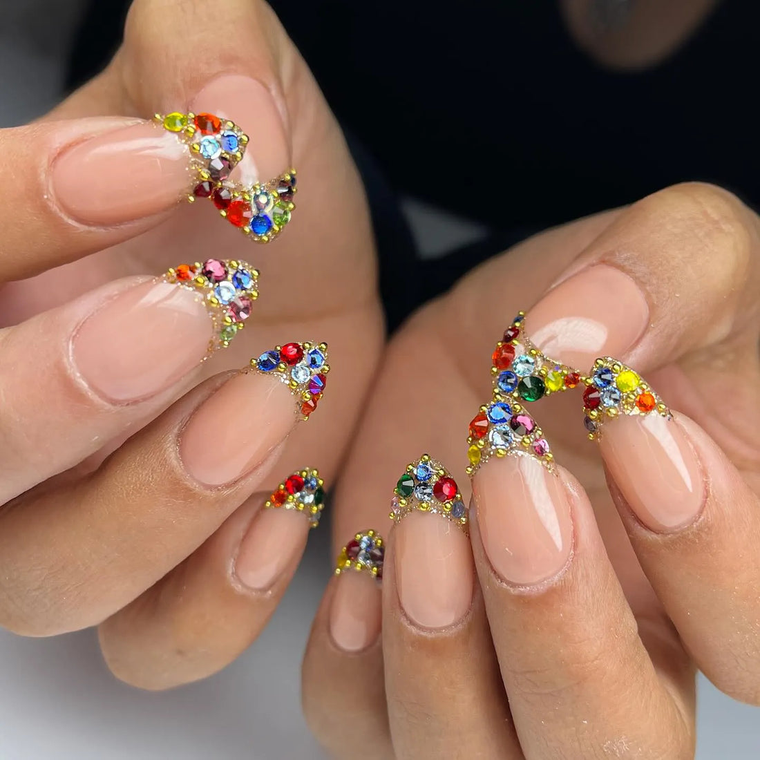 Handmade nude press-on nails with rainbow crystal French tips and jewel accents