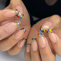 Handmade nude press-on nails with rainbow crystal French tips and jewel accents