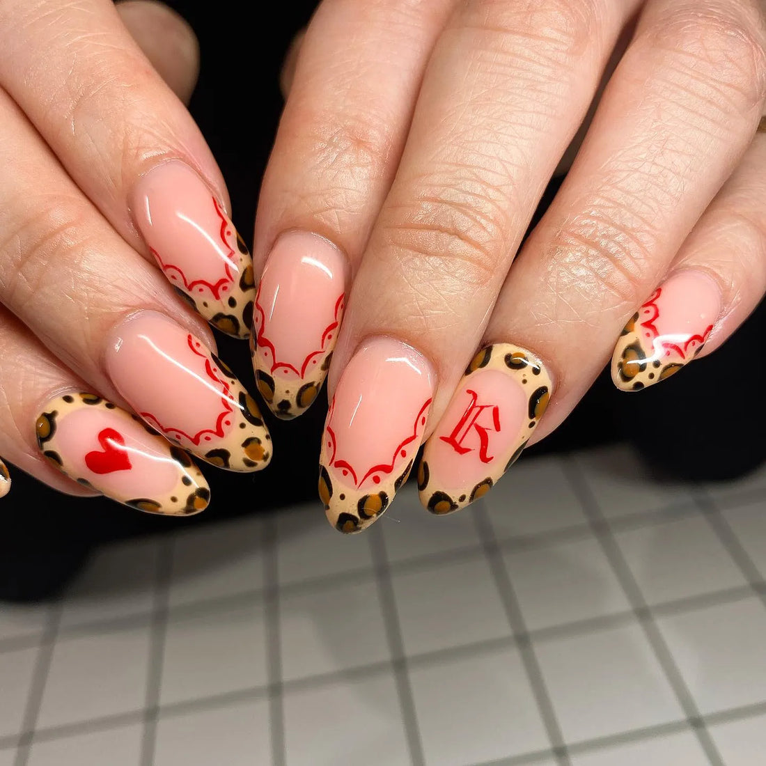 Handmade press-on nails with red heart, leopard print, lace French tips and letter accent design.